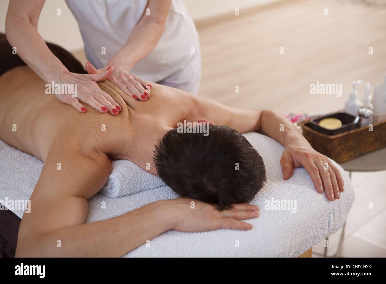 Unrecognizable man relaxing at spa center, getting professional back massage Stock Photo