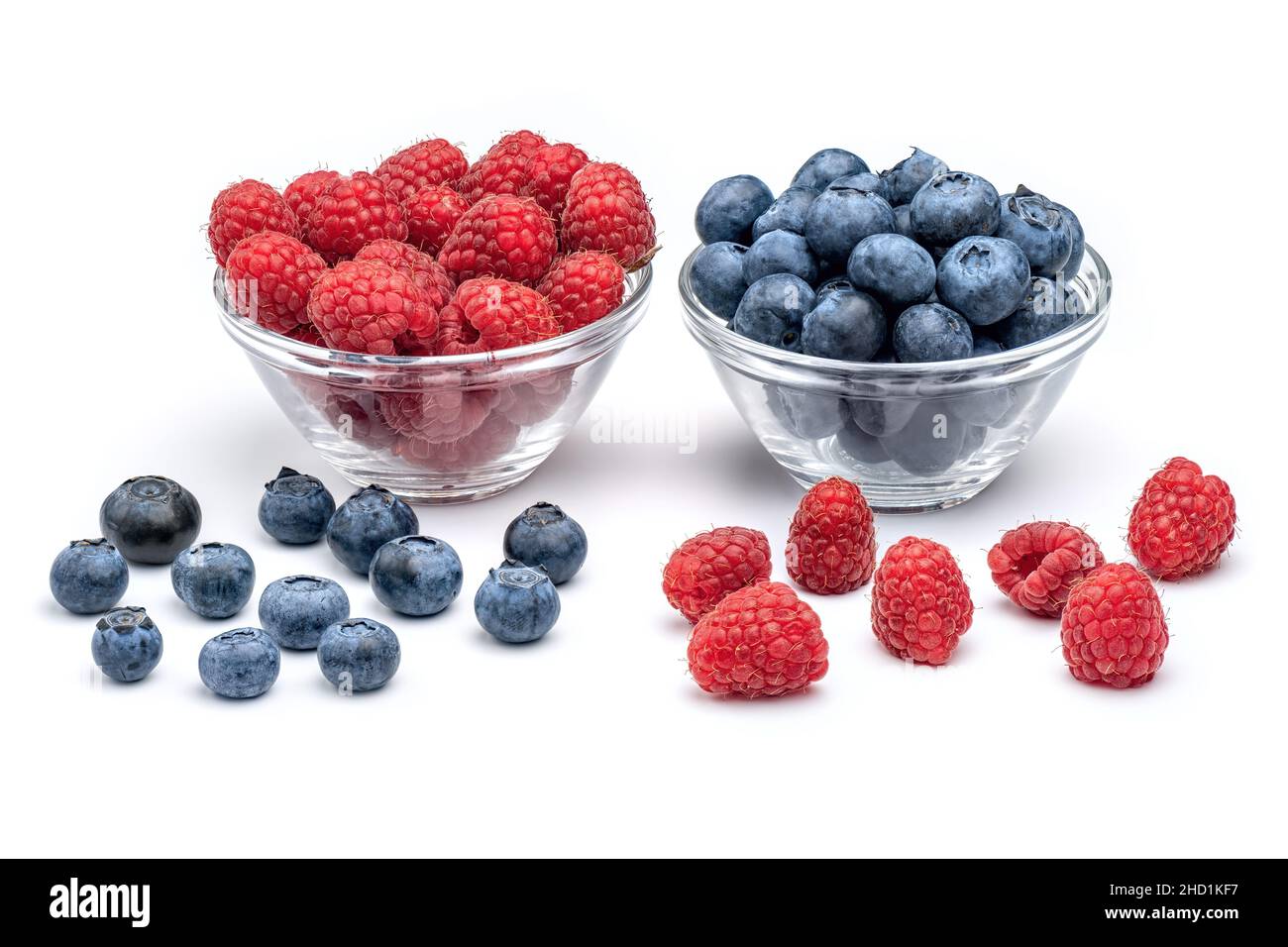 Fresh raspberries and blueberries in glass bowls isolated on white background. Berries in bowl. Stock Photo