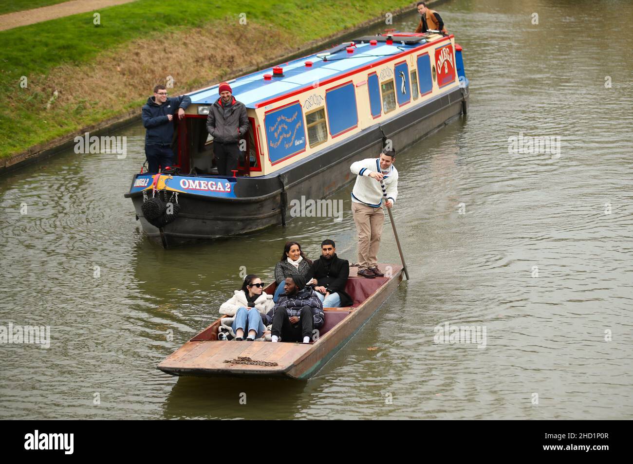 Narrowboat Omega 2 makes its way along the College Backs on the river Cam in Cambridge. A privilege afforded to Narrowboats once a year on New Years D Stock Photo