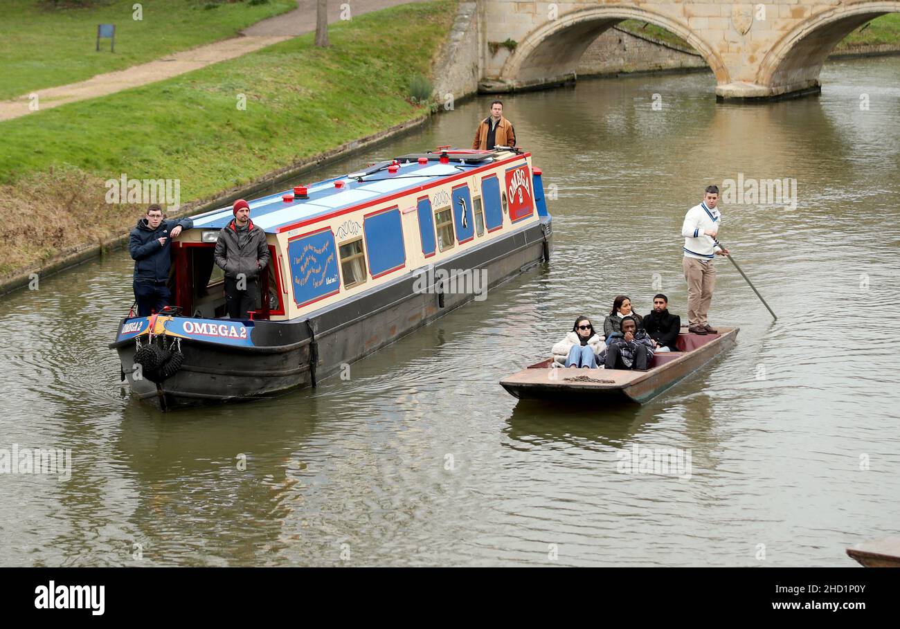 Narrowboat Omega 2 makes its way along the College Backs on the river Cam in Cambridge. A privilege afforded to Narrowboats once a year on New Years D Stock Photo