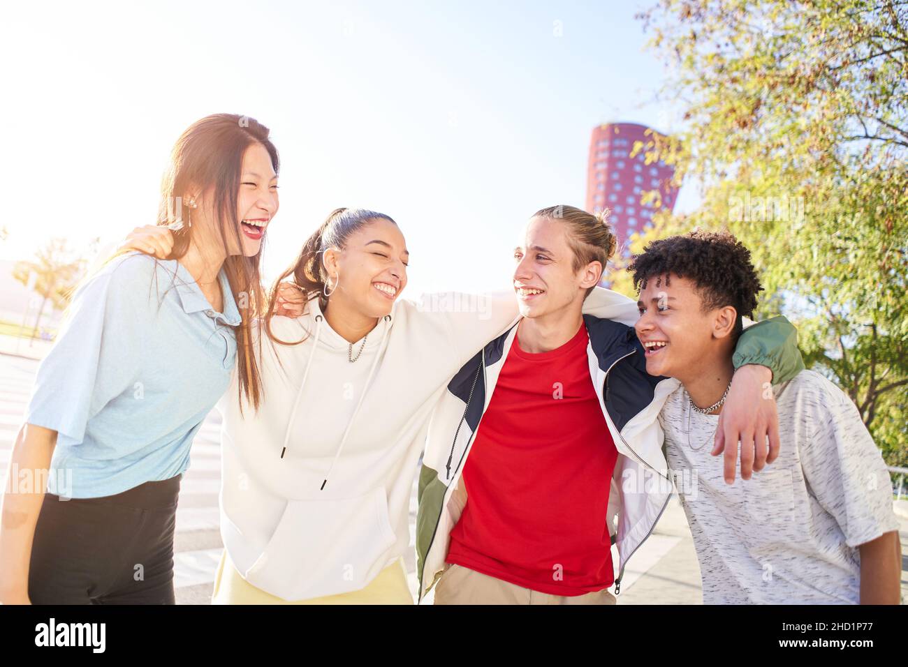 Multiracial group of young students laughing and hugging. People having ...