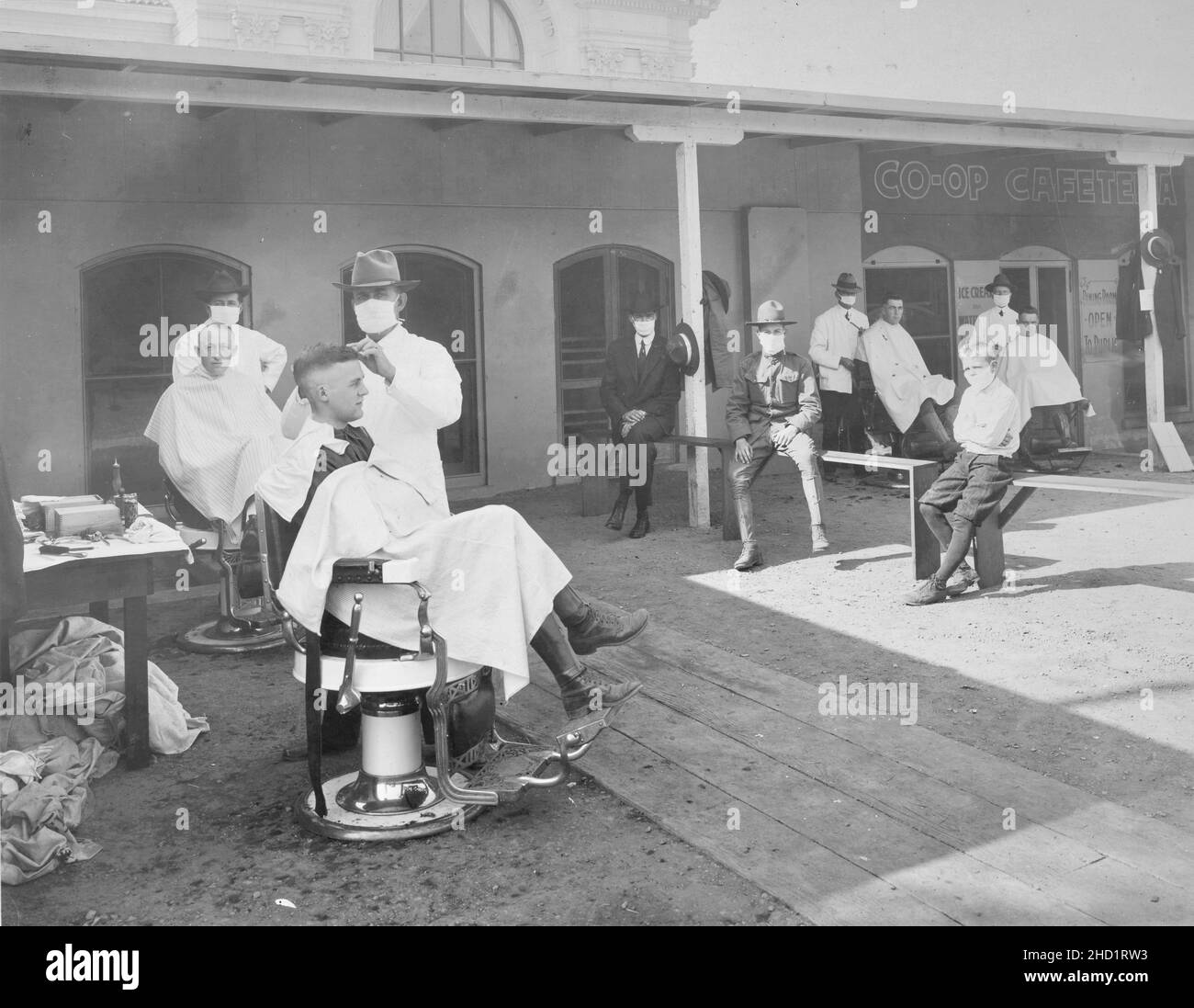 Vintage Photography - Mask wearing during the Spanish Flu pandemic of 1918 - Open air barber shop Stock Photo