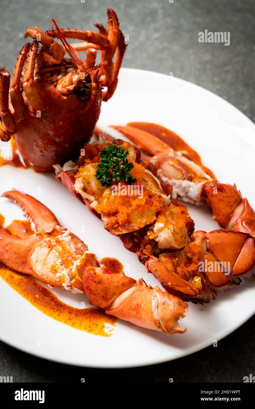 Lobster tail steak with sauce and shrimp eggs isolated on white