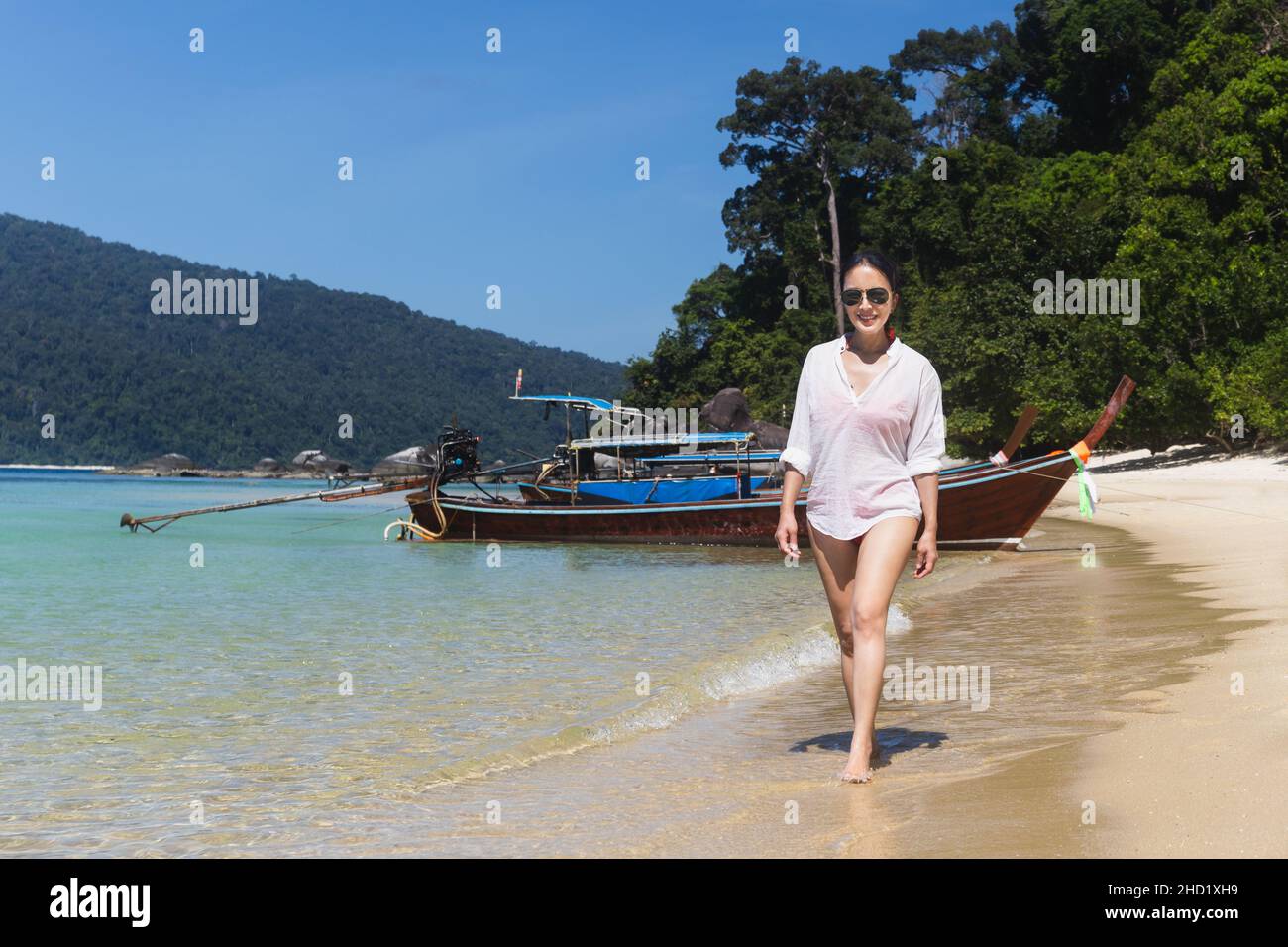 Asian woman walking on the beach with beautiful nature on vacation ...