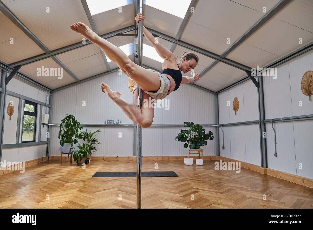 large pole dance studio with dancing instructura suspended in the air. Stock Photo