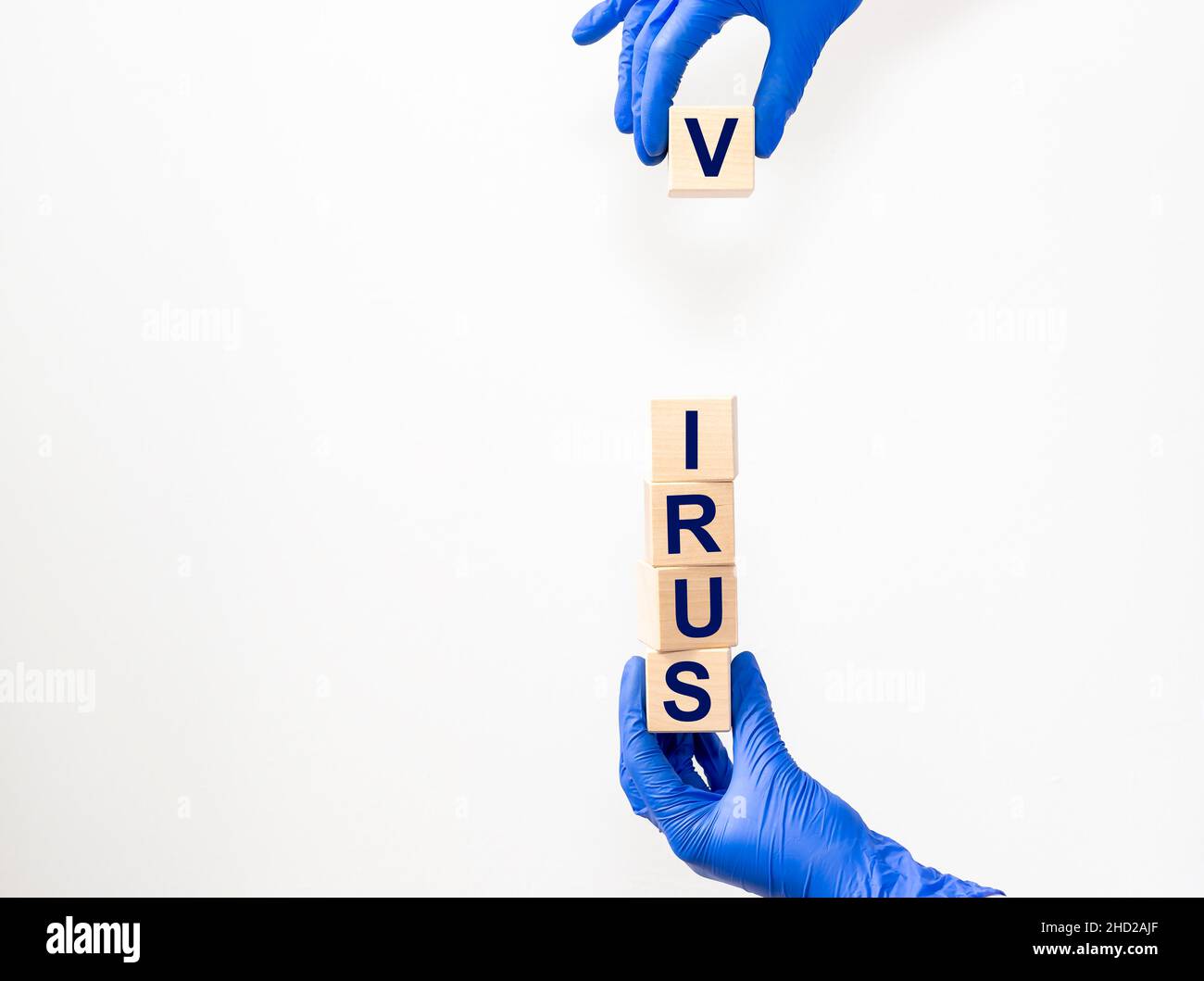 VIRUS word on cube blocks in hands in protective gloves on light white background Stock Photo