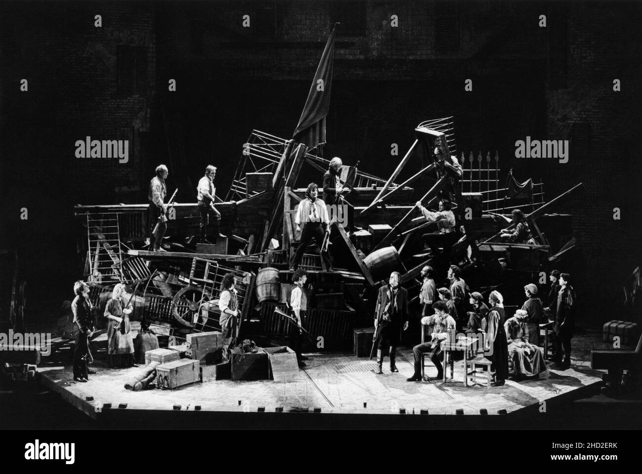 original London cast - revolutionaries at the barricades with (centre) David Burt (Enjoiras), stage right centre: Roger Allam (Javert) in LES MISERABLES at the Barbican Theatre, London EC2 08/10/1985   music: Claude-Michel Schonberg  text: Herbert Kretzmer  original text by Alain Boubil & Jean-Marc Natel   additional material: James Fenton  based on the novel by Victor Hugo  adapted & directed by Trevor Nunn & John Caird  set design: John Napier  costumes: Andreane Neofitou  lighting: David Hersey  a Royal Shakespeare Company (RSC) & Cameron Mackintosh co-production   transferred to the Palace Stock Photo