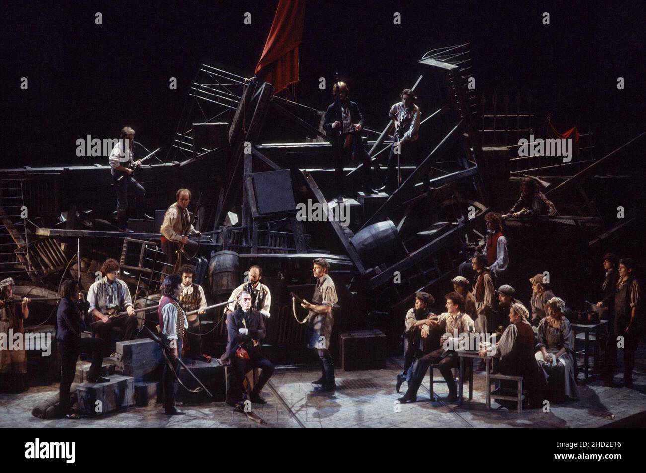 original London cast - revolutionaries at the barricades with (seated centre) Roger Allam (Javert) in LES MISERABLES at the Barbican Theatre, London EC2 08/10/1985   music: Claude-Michel Schonberg  text: Herbert Kretzmer  original text by Alain Boubil & Jean-Marc Natel   additional material: James Fenton  based on the novel by Victor Hugo  adapted & directed by Trevor Nunn & John Caird  set design: John Napier  costumes: Andreane Neofitou  lighting: David Hersey  a Royal Shakespeare Company (RSC) & Cameron Mackintosh co-production   transferred to the Palace Theatre, London W1 04/12/1985-2004 Stock Photo