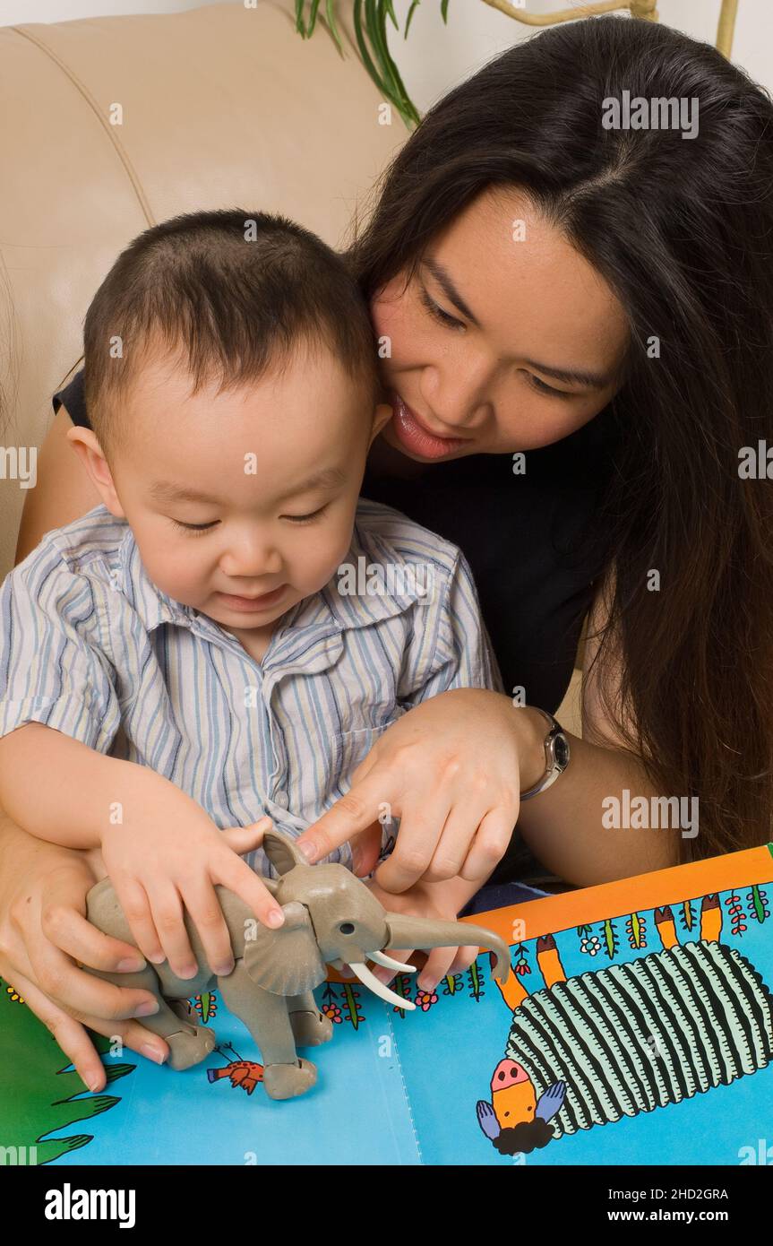 Vietnamese American family at home, mother helping toddler son to name