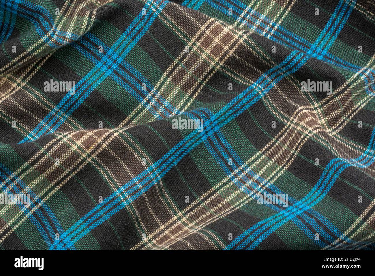 Close-up of blue check flannel fabric, showing warp and weft pattern thread pattern and blue stitching. Stitched line, lines of stitches. Stock Photo
