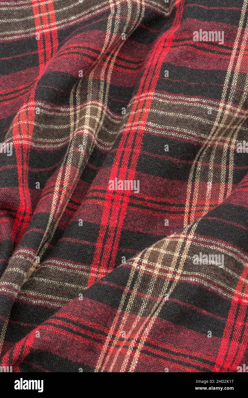 Close-up of red check flannel fabric, showing warp and weft pattern thread pattern and orange stitching. Stitched line, lines of stitches Stock Photo