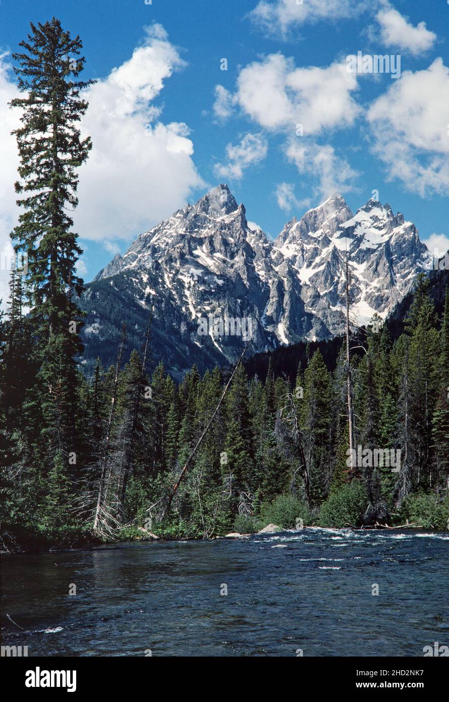 The peaks of Grand Teton National Park with flowing water on a bright, sunny day. Stock Photo