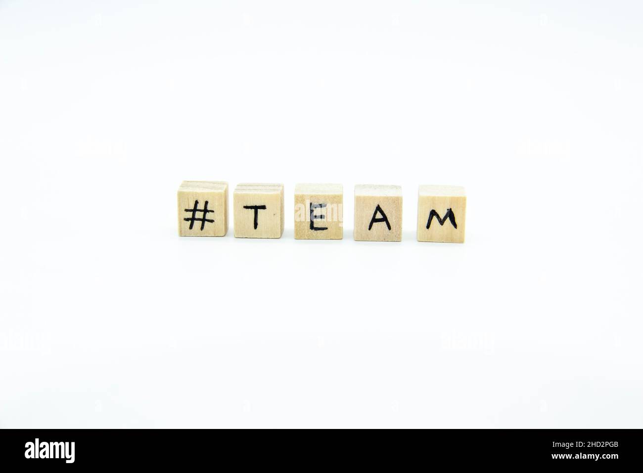 Word TEAM written on the wood cubes on white  background. The concept photo with letters #team Stock Photo