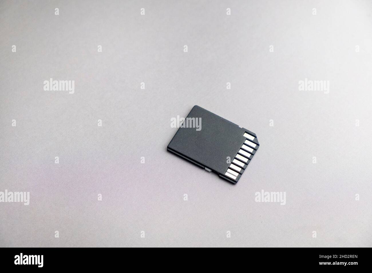 black micro sd card with gold contacts on a gray metallic surface, selective focus, macro Stock Photo