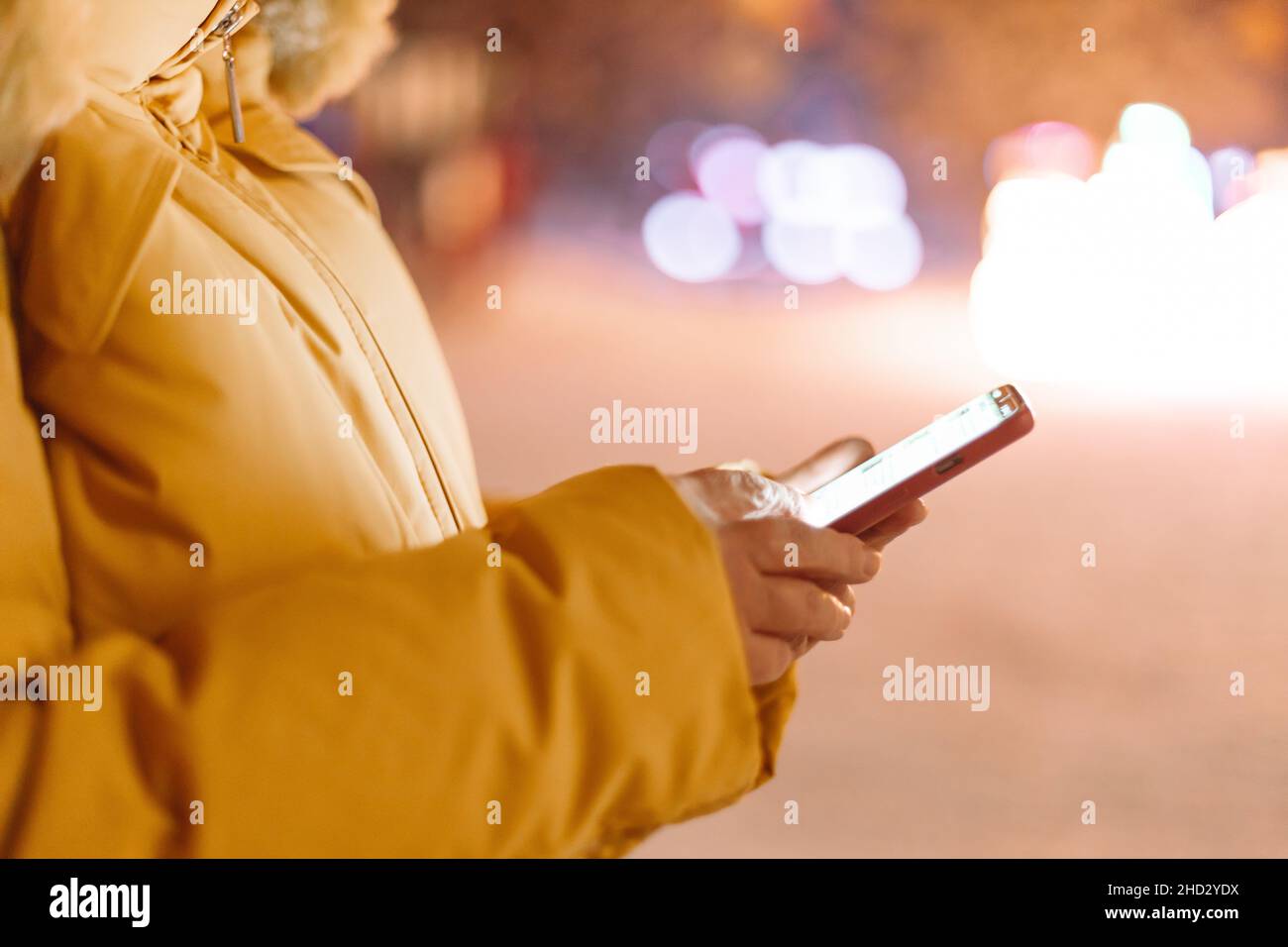 Beautiful 40s 50s woman using mobile phone during shopping in wintertime Stock Photo