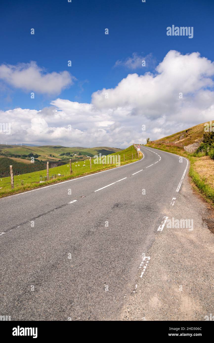 Road through sunlit countryside, Ceredigion, Wales Stock Photo