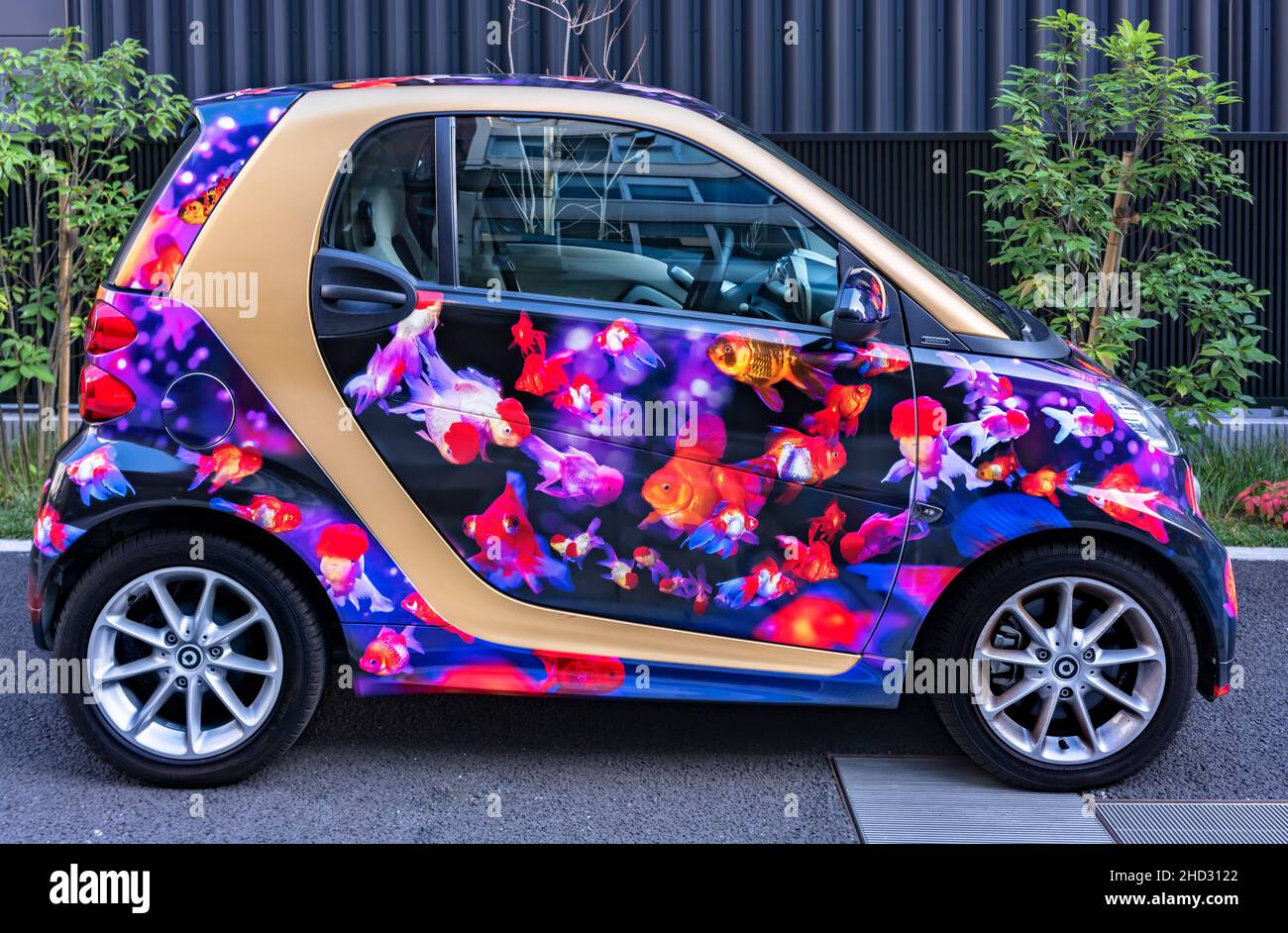tokyo, japan - july 18 2021: Microcar of the brand called smart adorned with a vehicle vinyl wrap depicting Japanese multihued goldfishes with long ta Stock Photo