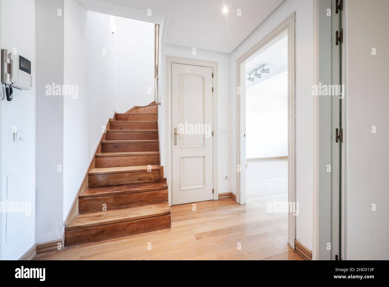 Duplex house with wooden stairs and entrance to a large living room Stock Photo