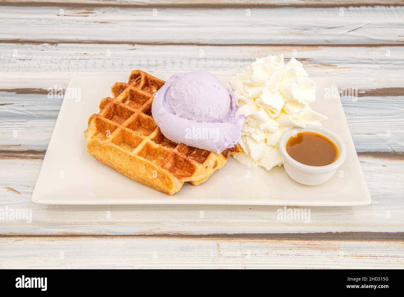 Crispy waffle-shaped cake of Belgian origin that is cooked between two dishes, to this was added a scoop of ice cream with the aroma of floras and lot Stock Photo
