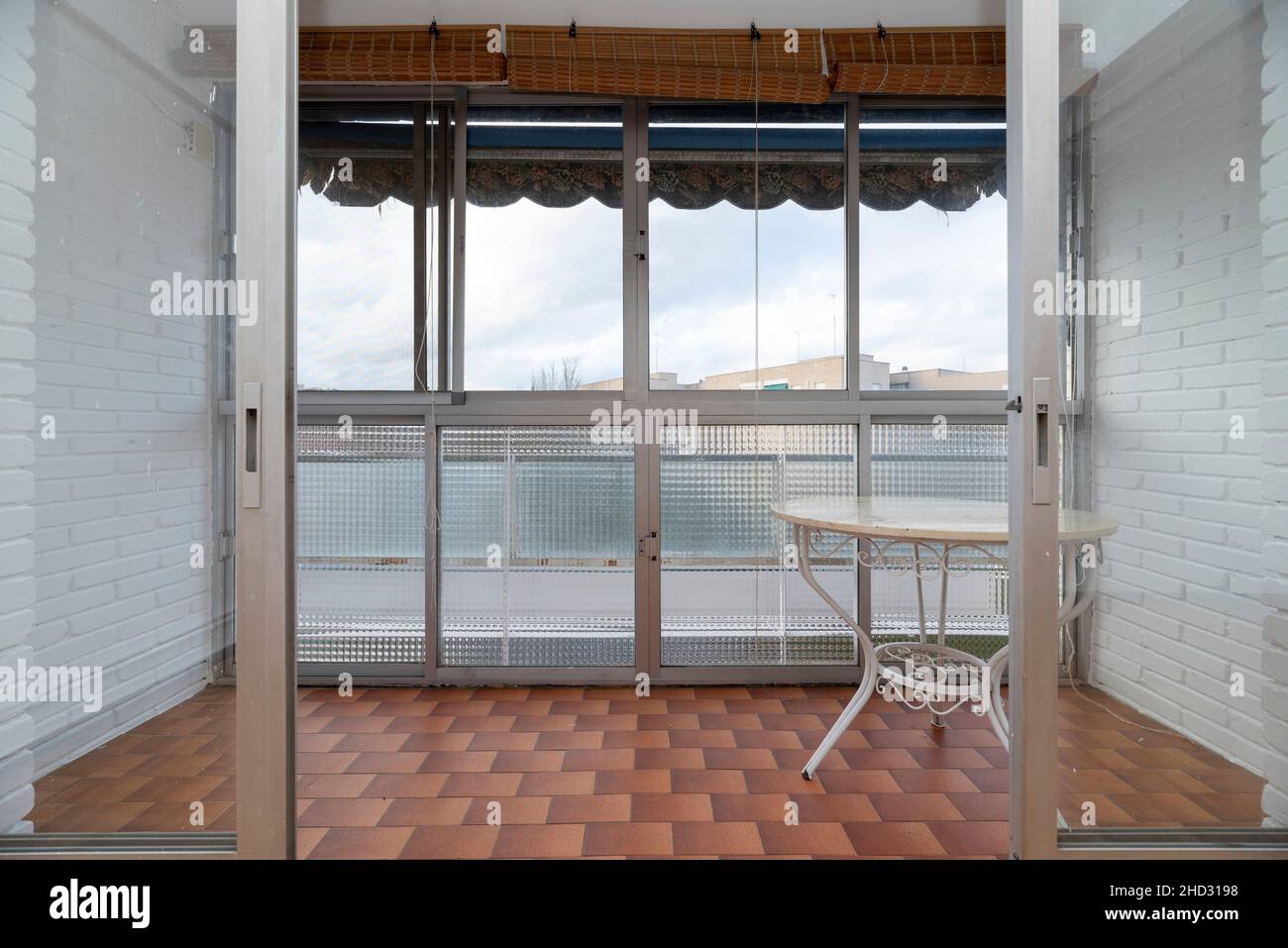sunroom with white brick walls table for leisure and awnings against