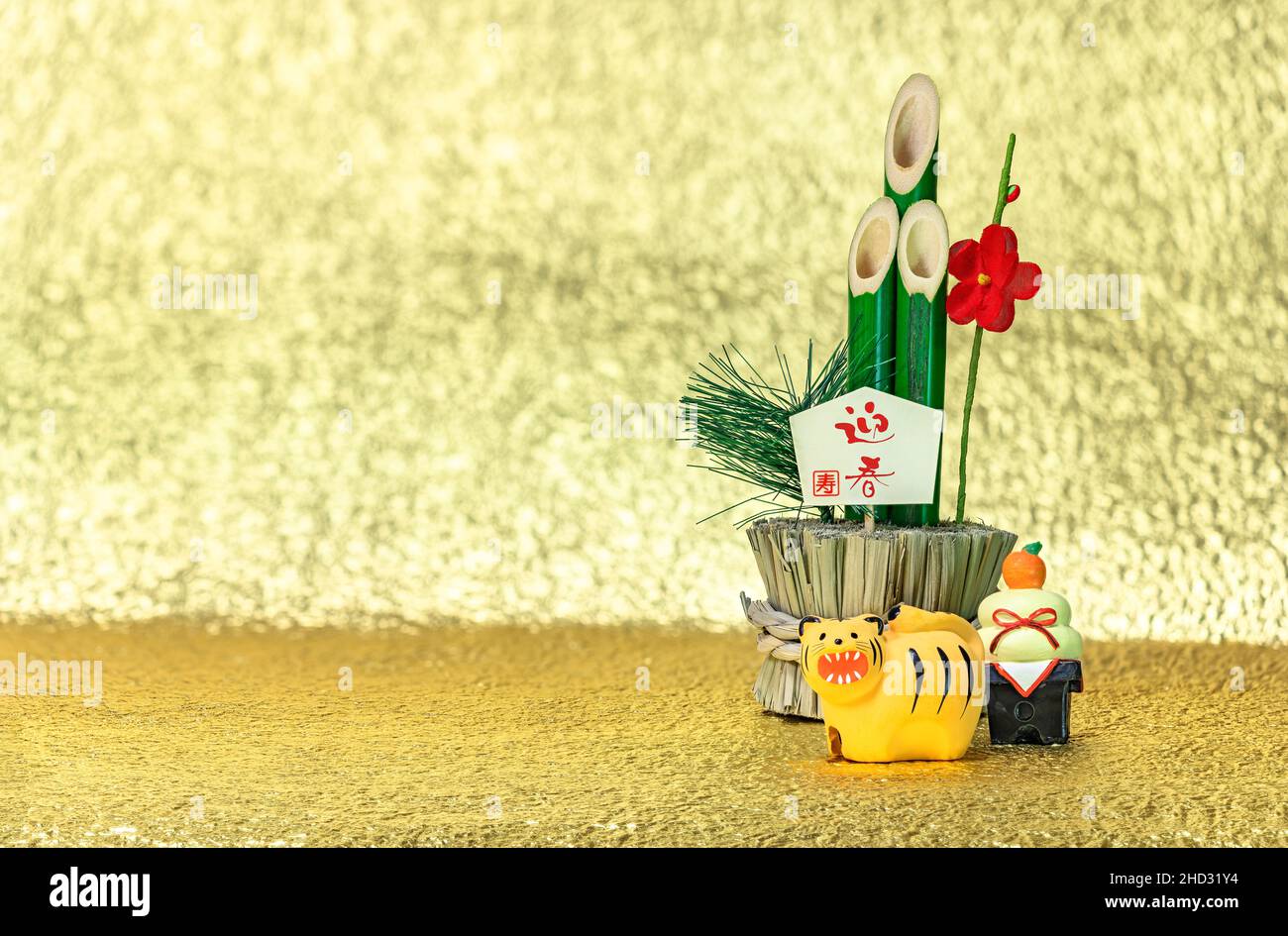 Japanese New Year's Greeting Card of a bamboo kadomatsu with the words congratulations for the welcoming spring, a kagami mochi rice cake and a cute f Stock Photo