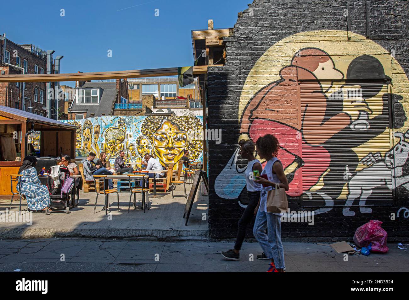 Visiting the street art and grafitti on the famous streets of Brick Lane Market , East London . East london shoreditch district has become iconic . Stock Photo