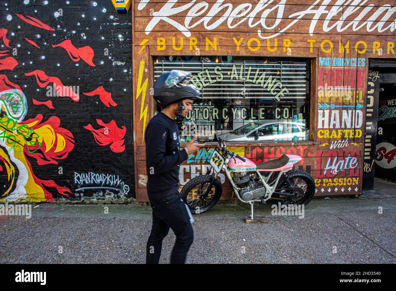 Colourful shop front covered in handpainted signage and wooden panelling in trendy Shoreditch, East London Stock Photo