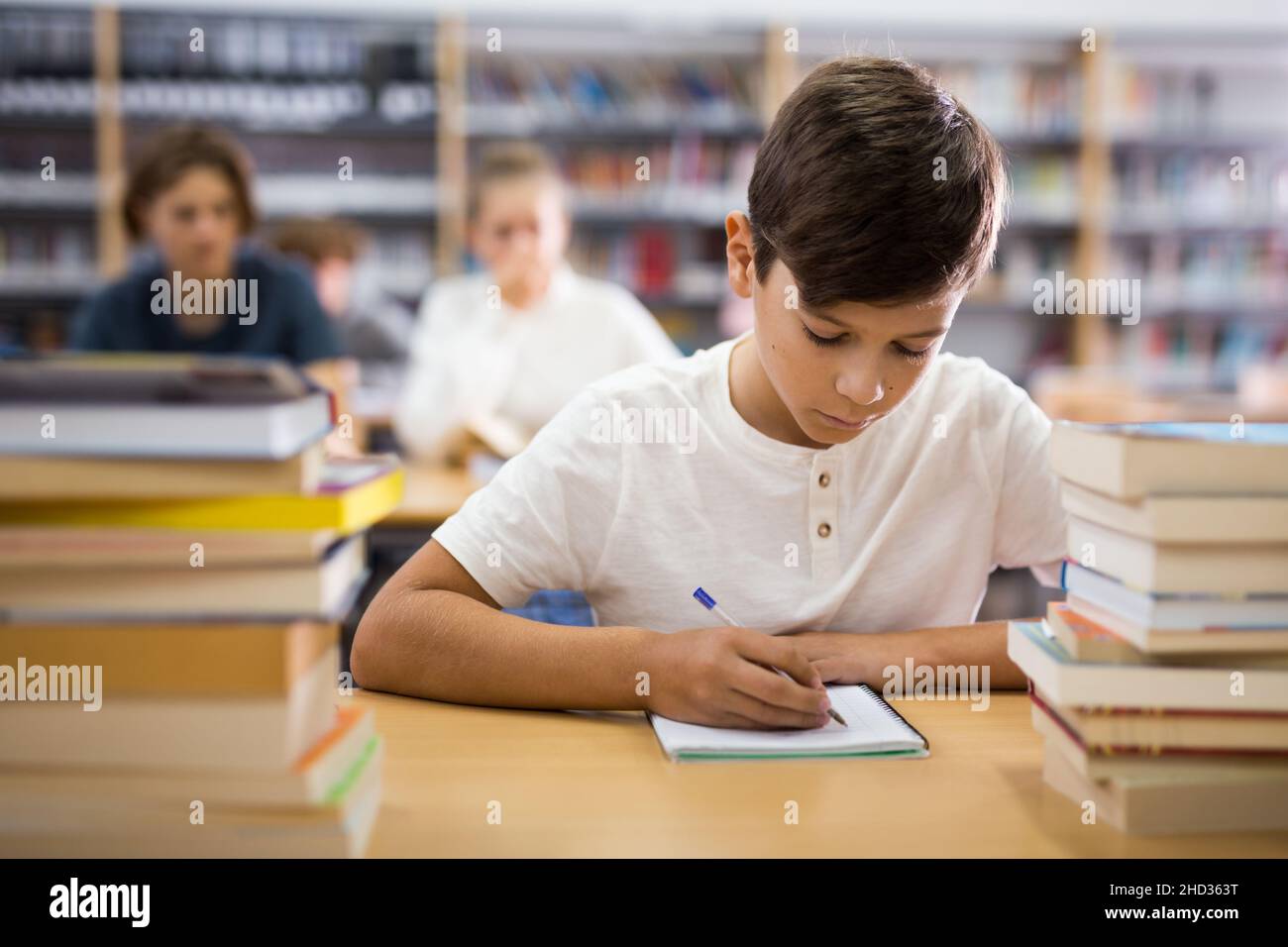 Library Do Homework Young boy doing homework in library Stock Photo - Alamy