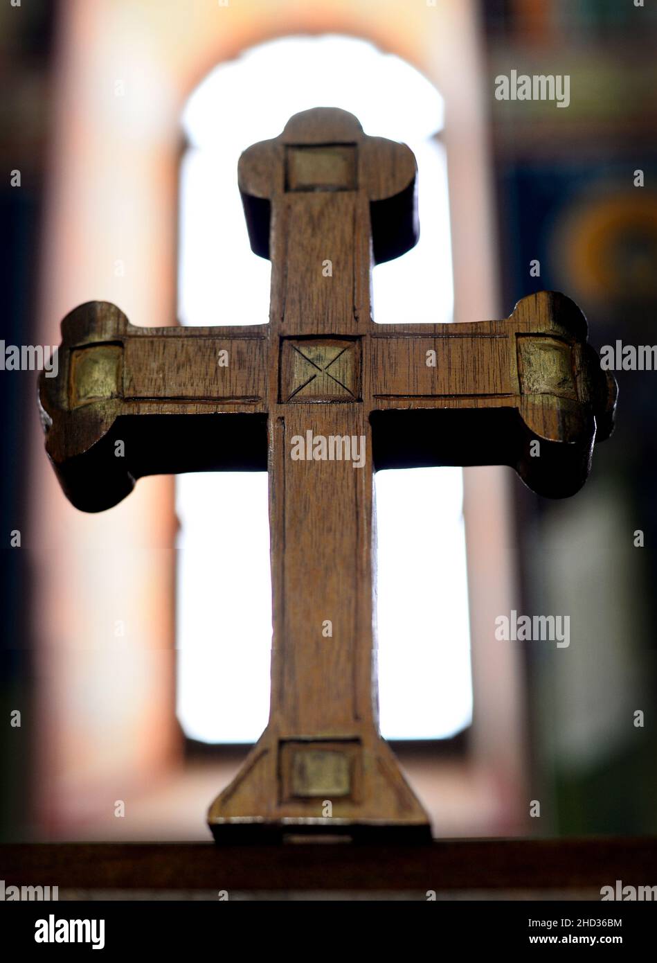 Closeup shot of a wooden ornamented cross against a blurred background inside the church Stock Photo