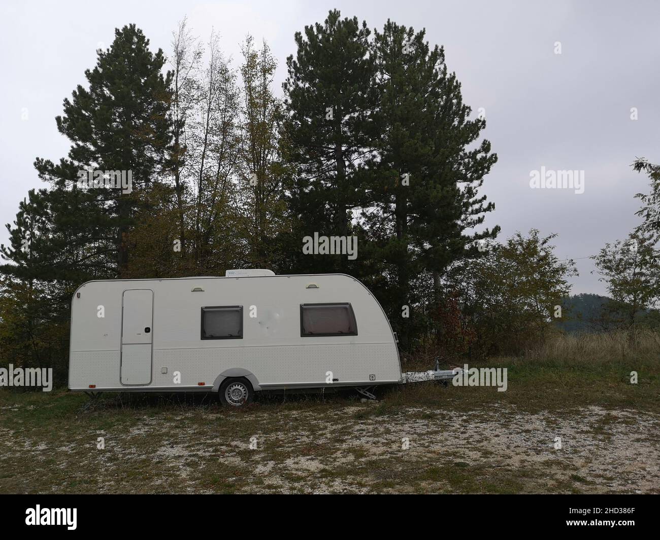 Caravan parked in the woods on a cloudy day Stock Photo