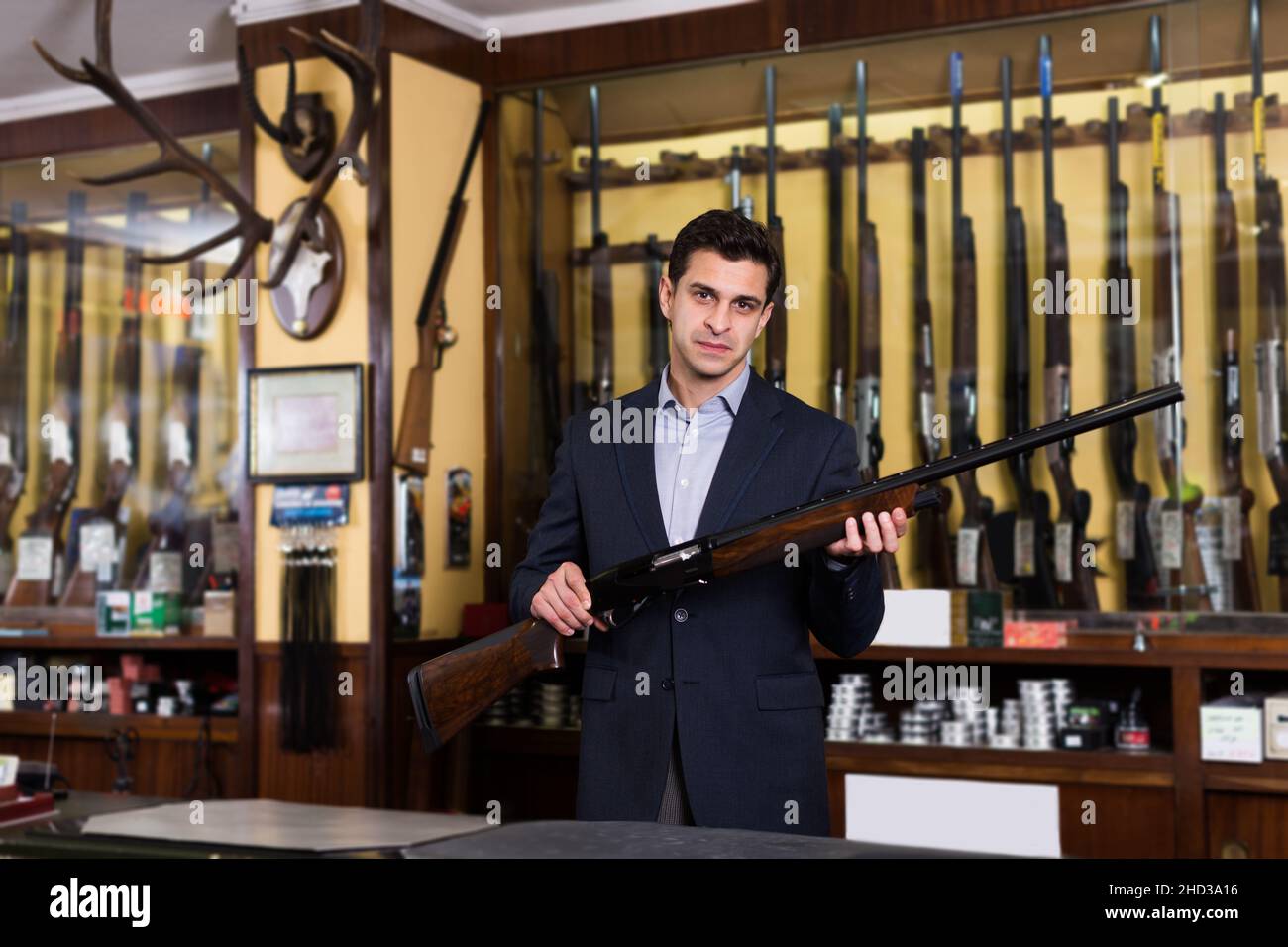 Male seller in hunting shop demonstrating shotgun Stock Photo - Alamy