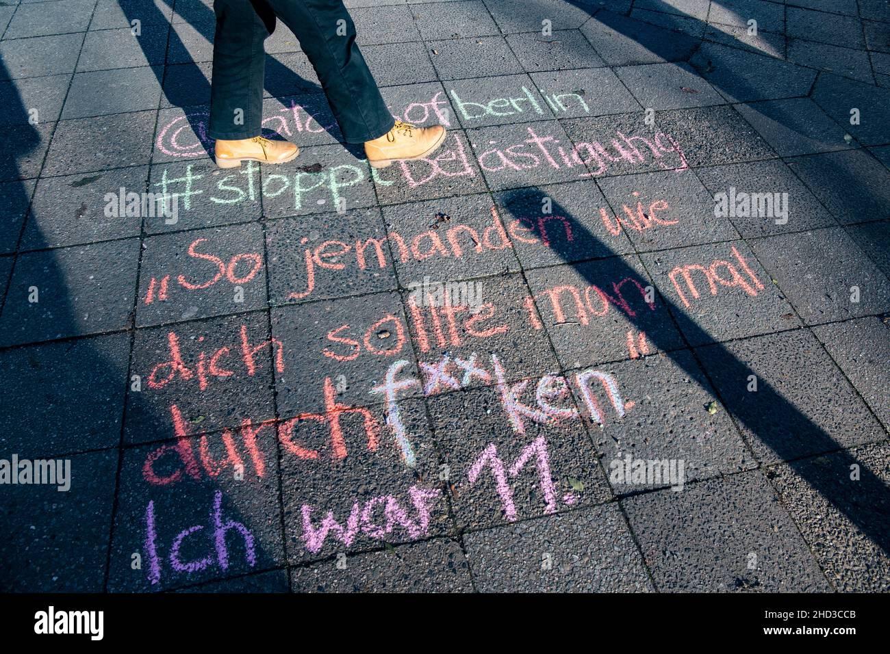 20 December 2021, Berlin: Student Lucie wrote with chalk '@catcallsofberlin - #stopptästigung - 'Jemanden wie dich sollte man mal ordentlich durchf**ken. - I was eleven'' written on a sidewalk. The lewd saying is later posted on the Instagram page 'catcallsofberlin'. Armed with colorful chalk, the initiative fights against 'catcalling' - verbal and physical sexualized harassment on the street. 'Catcalling' includes inappropriate comments and gestures as well as whistles or suggestive noises and intrusive glances. (to dpa-Korr 'Catcalling': Activists chalk up sexualized harassment') Photo: Paul Stock Photo