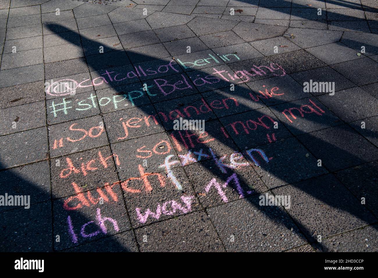 20 December 2021, Berlin: Student Lucie wrote with chalk '@catcallsofberlin - #stopptästigung - 'Jemanden wie dich sollte man mal ordentlich durchf**ken. - I was eleven'' written on a sidewalk. The lewd saying is later posted on the Instagram page 'catcallsofberlin'. Armed with colorful chalk, the initiative fights against 'catcalling' - verbal and physical sexualized harassment on the street. 'Catcalling' includes inappropriate comments and gestures as well as whistles or suggestive noises and intrusive glances. (to dpa-Korr 'Catcalling': Activists accuse sexualized harassment') Photo: Paul Z Stock Photo