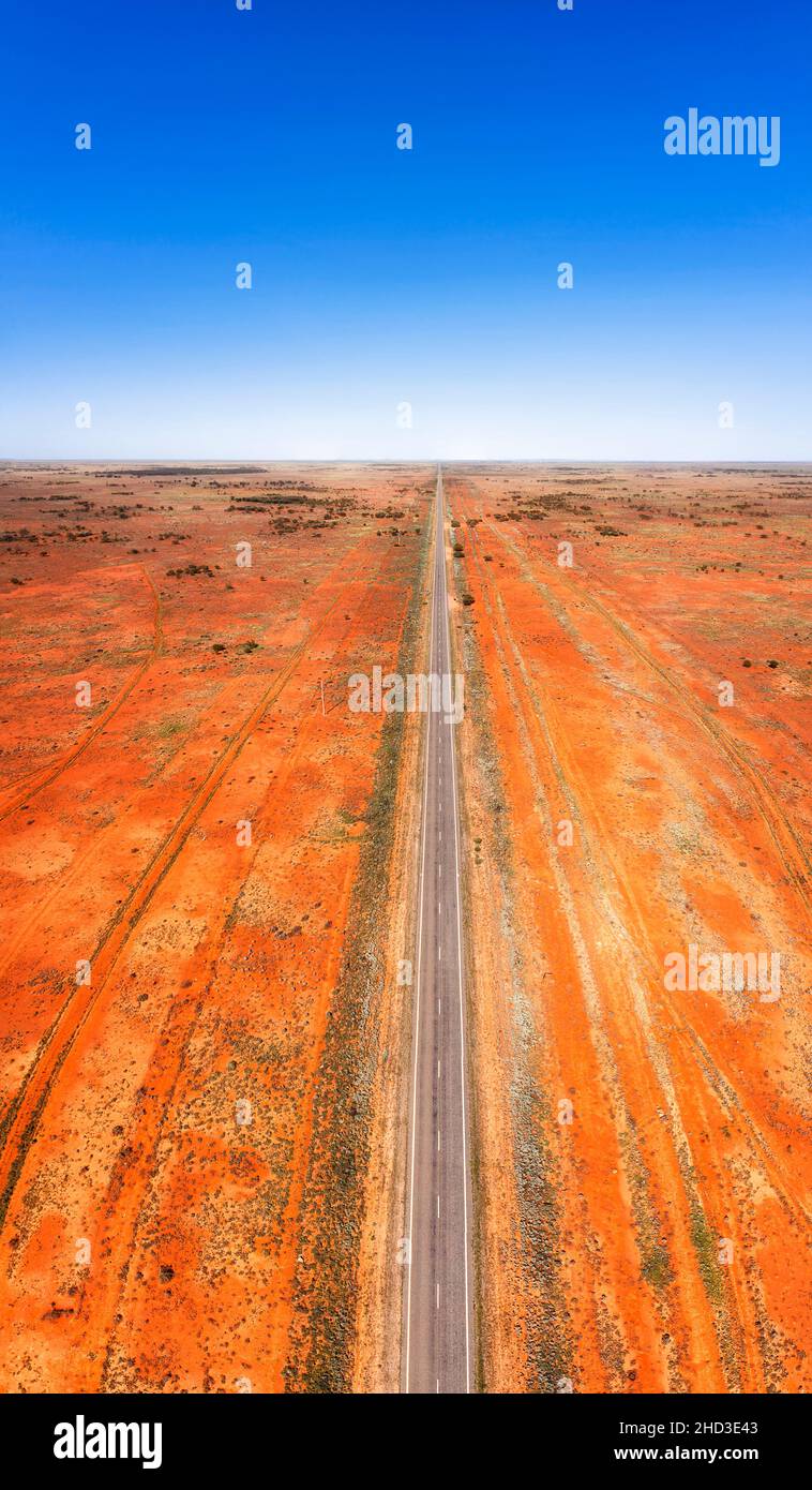 Straight endless strip of Barrier highway in Australian outback near Broken Hill - vertical aerial landscape with red soil. Stock Photo