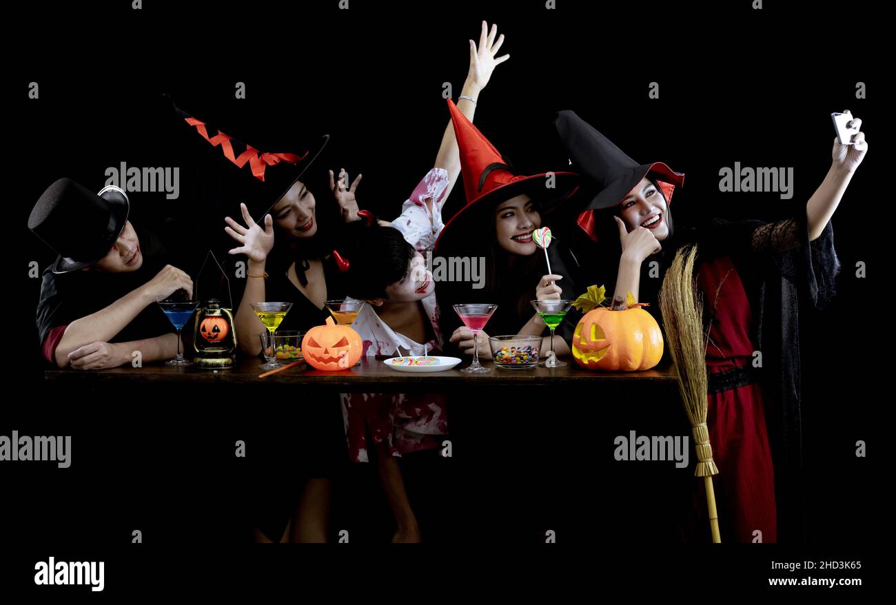 Group young Asian in costume celebrate Halloween party and selfie on black background. Gang of teen Asian in cosplay Halloween. Costume ghost, evil of Stock Photo