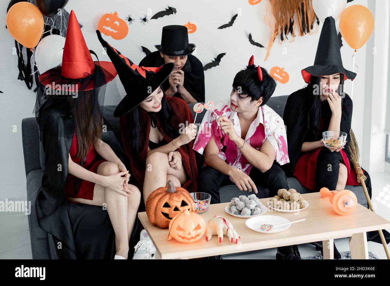 Group young Asian in costume witch, wizard, hell celebrate party in the room for theme Halloween at home. Gang teen Thai with celebrate Halloween part Stock Photo