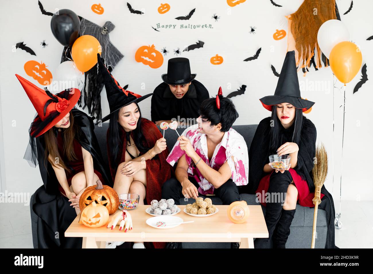 Group young Asian in costume witch, wizard, hell celebrate party in the room for theme Halloween at home. Gang teen Thai with celebrate Halloween part Stock Photo