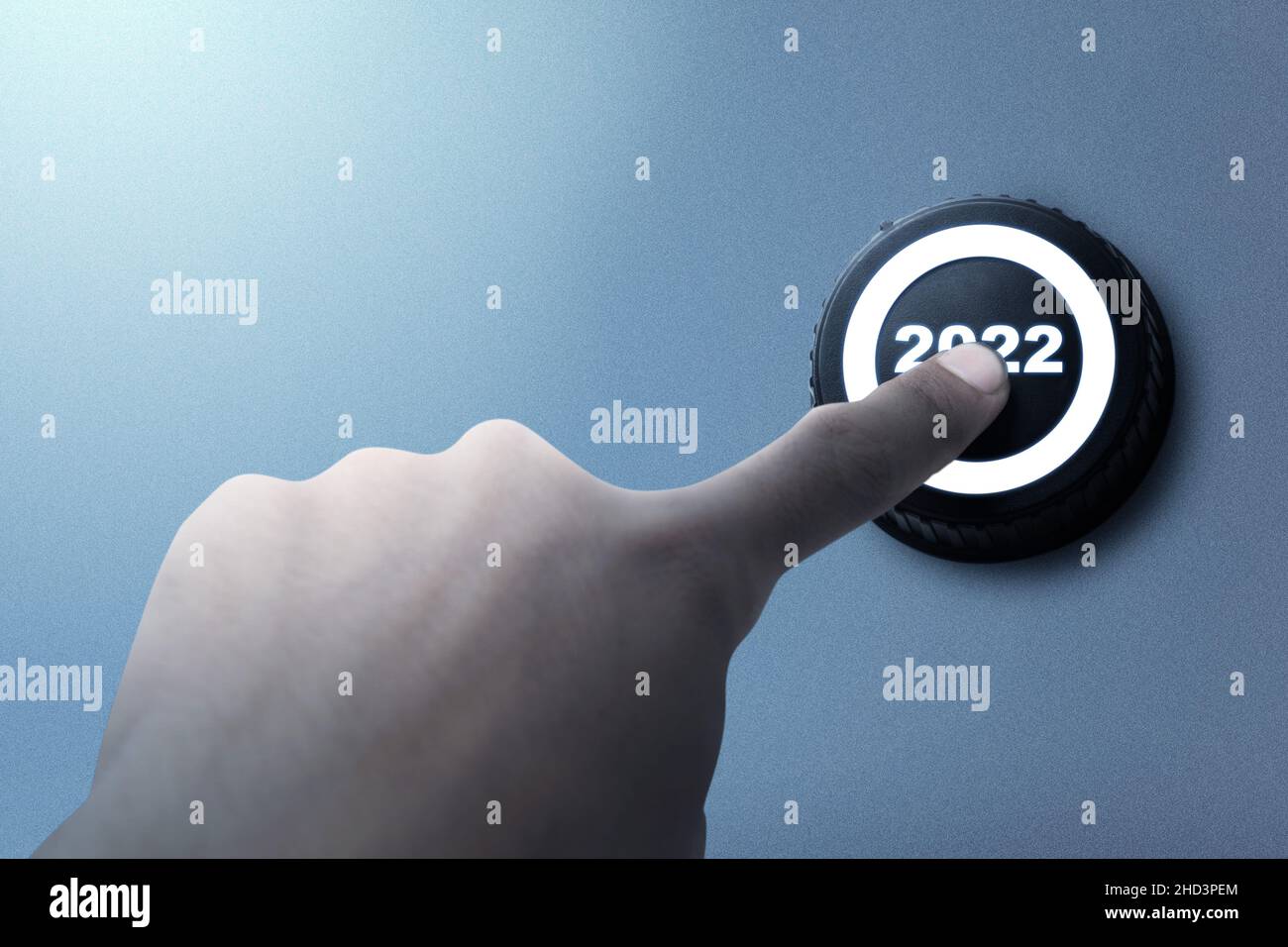 A human hand pushes the 2022 button. Happy New Year 2022 Stock Photo