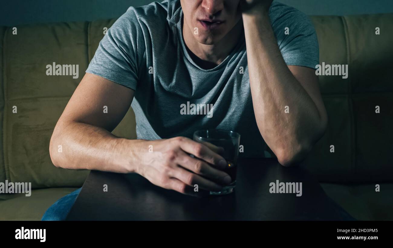 unrecognizable man drinks whiskey from glass Stock Photo