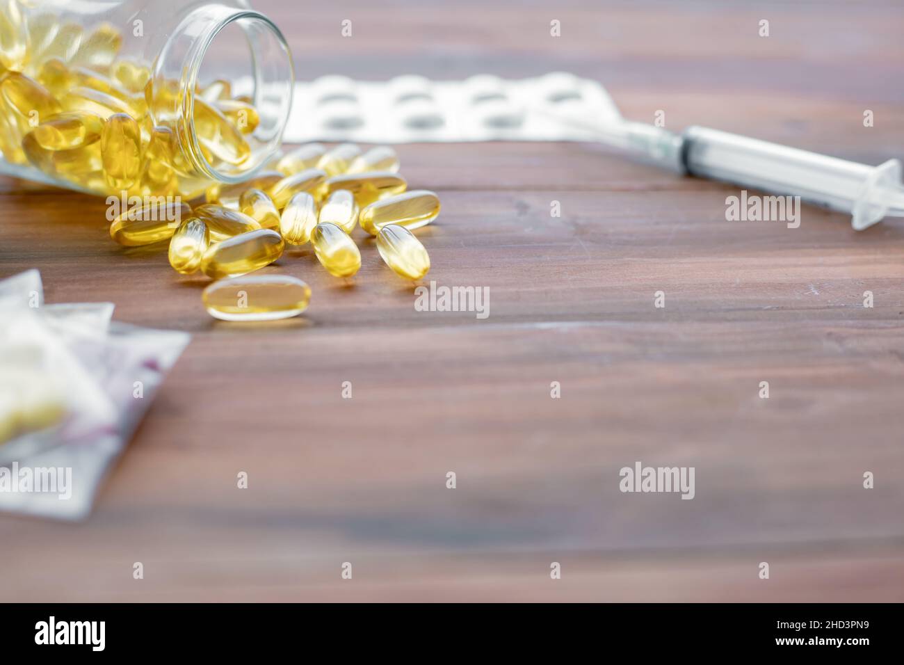 Medicine concept on wood background with copy space. Gold fish oil capsules. Concept of medicine in medical. Stock Photo