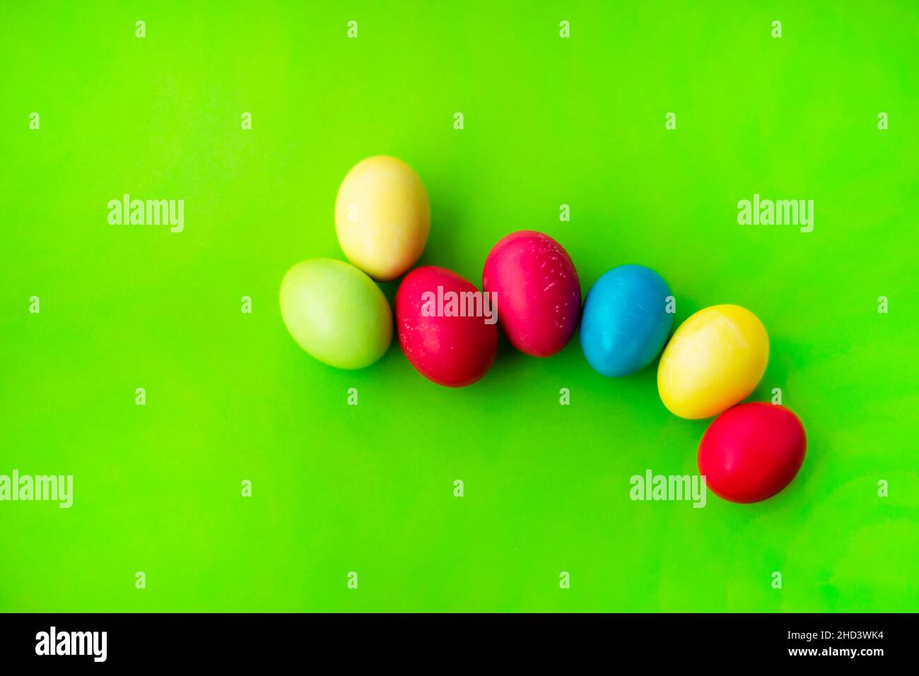 Easter themes. Multi-colored eggs on a bright green grassy background. Copy space for text. Stock Photo