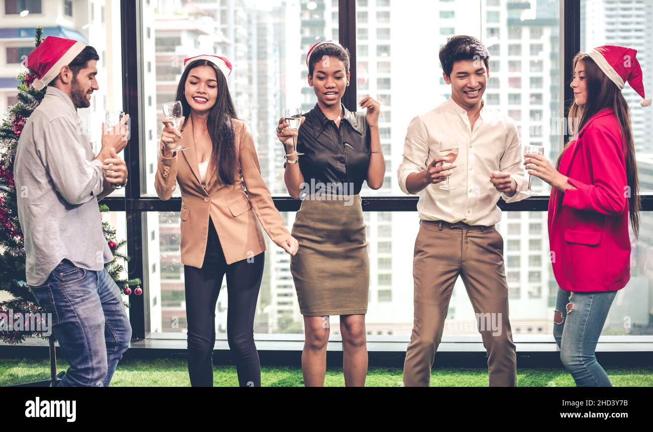 Group of office workers celebrating Christmas and New Year with dance and hold drink wine with happy and smile in the company. Concept of the celebrat Stock Photo