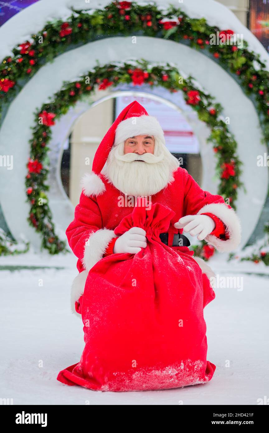 Santa Claus posing with a bag of gifts on the background of Christmas ...