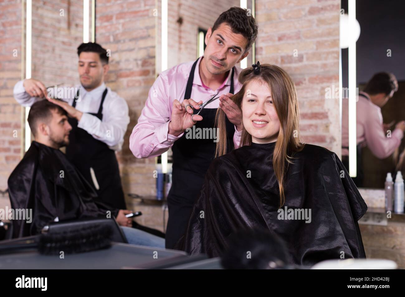 Brunette getting haircutting in salon Stock Photo
