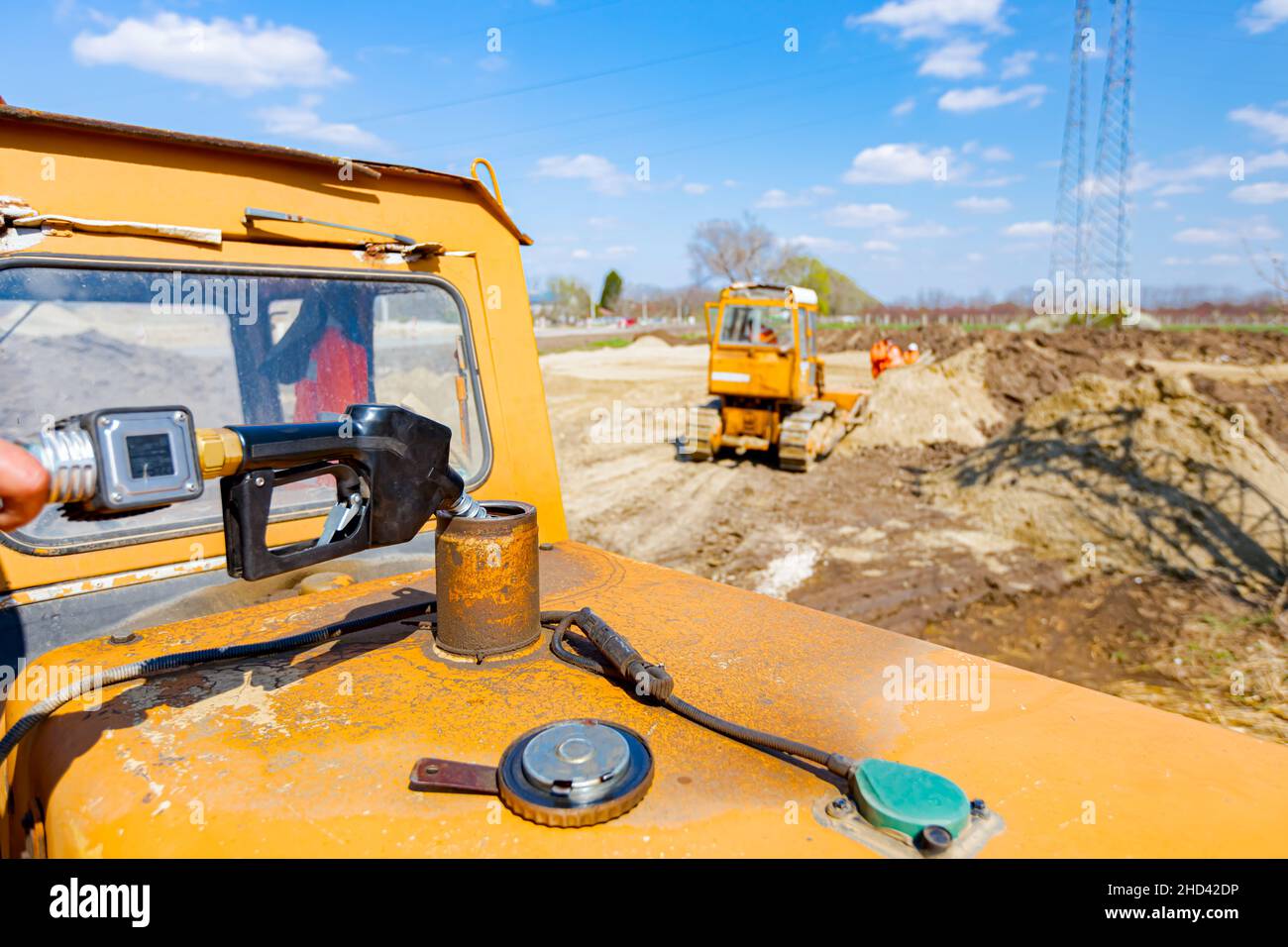 Fuel pump gun inserted in the reservoir of construction machine, pour