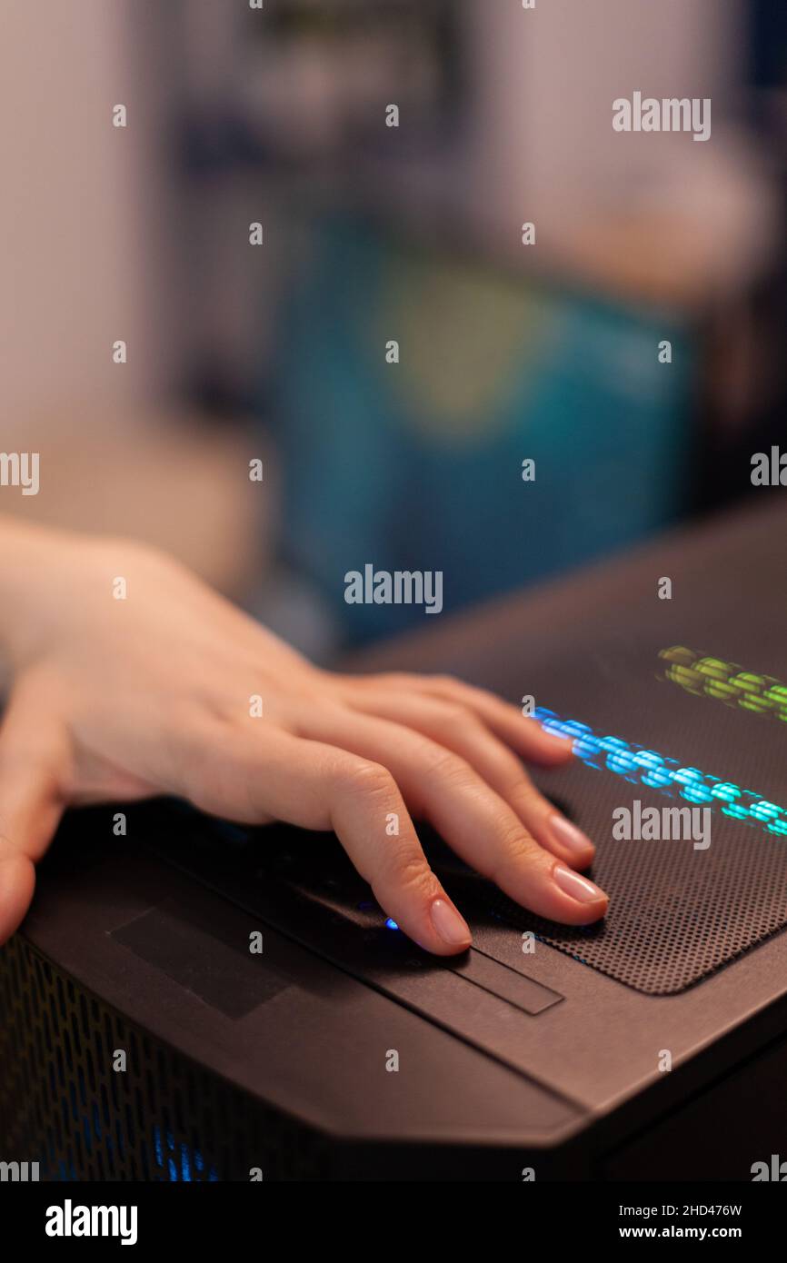 Woman gamer pressing button on RGB computer preparing for space ...