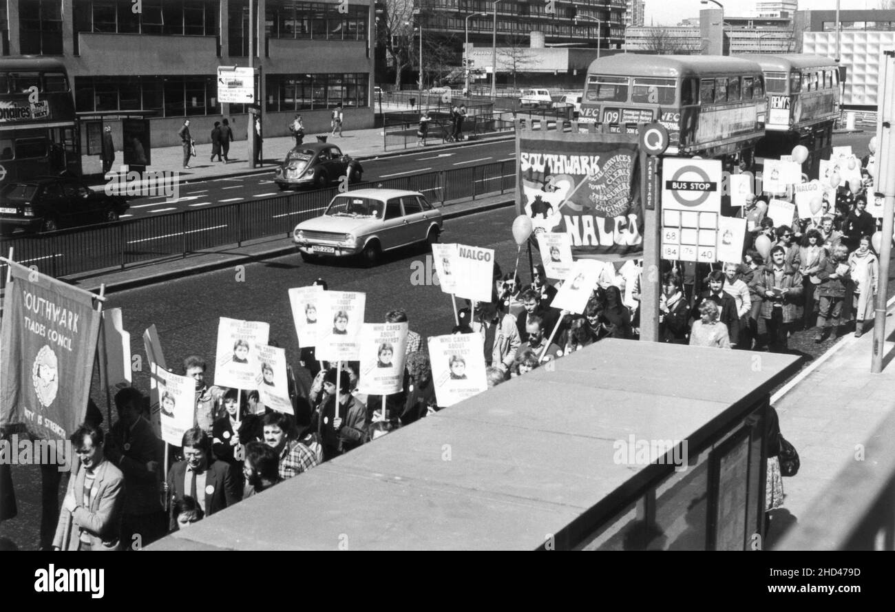 A demonstration march by members of the Southwark branch of the British trade union, NALGO (National and Local Government Officers' Association) and Southwark Trades Council, protesting against the dismissal of a worker from Southwark London Borough Council. Mid 1980s. The photograph depicts the marchers passing the Elephant and Castle Shopping Centre, Southwark, London. The protestors are carrying the Southwark Branch NALGO and Southwark Trades Council banners, balloons and placards with the slogan, “Who Cares About Workers? – Not Southwark Council”. Stock Photo