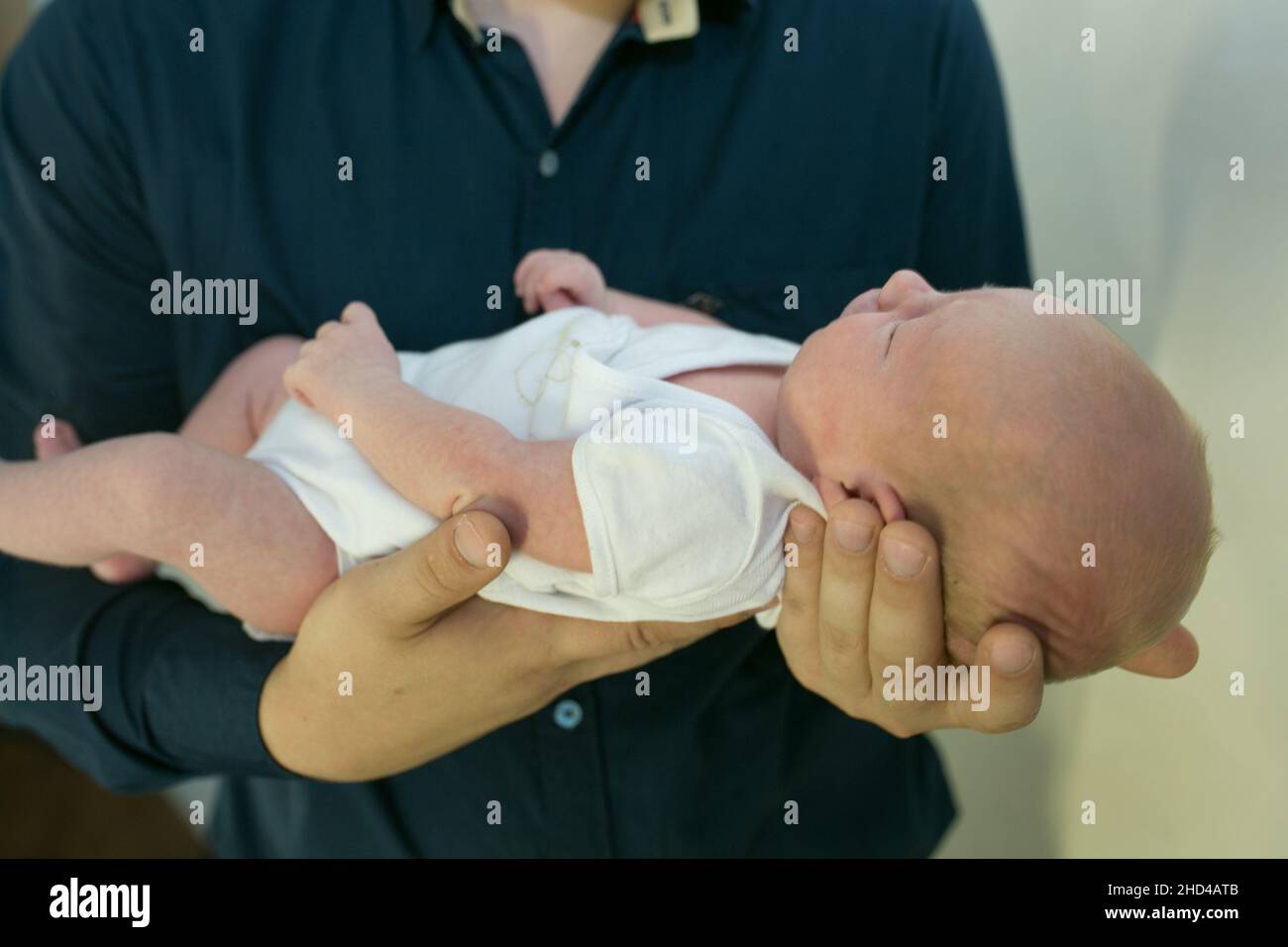 Close-up small hands of baby is lying in men of his father hands, concept  of caring, fatherhood Stock Photo