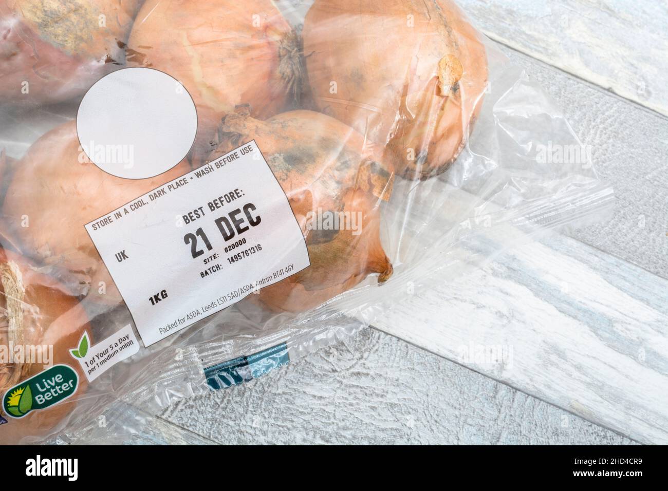 ASDA plastic packed Brown Onions / Allium cepa. Also called yellow onions + Best Before Date label / BBD. For common kitchen ingredients & medicinal. Stock Photo