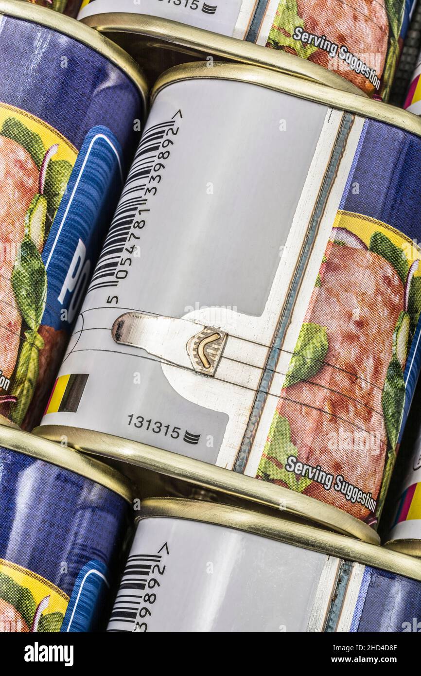 Close shot twist-key tin opener / can-opener on an ASDA luncheon meat tinned product. Concept for food preservation, opening a can of worms. Stock Photo